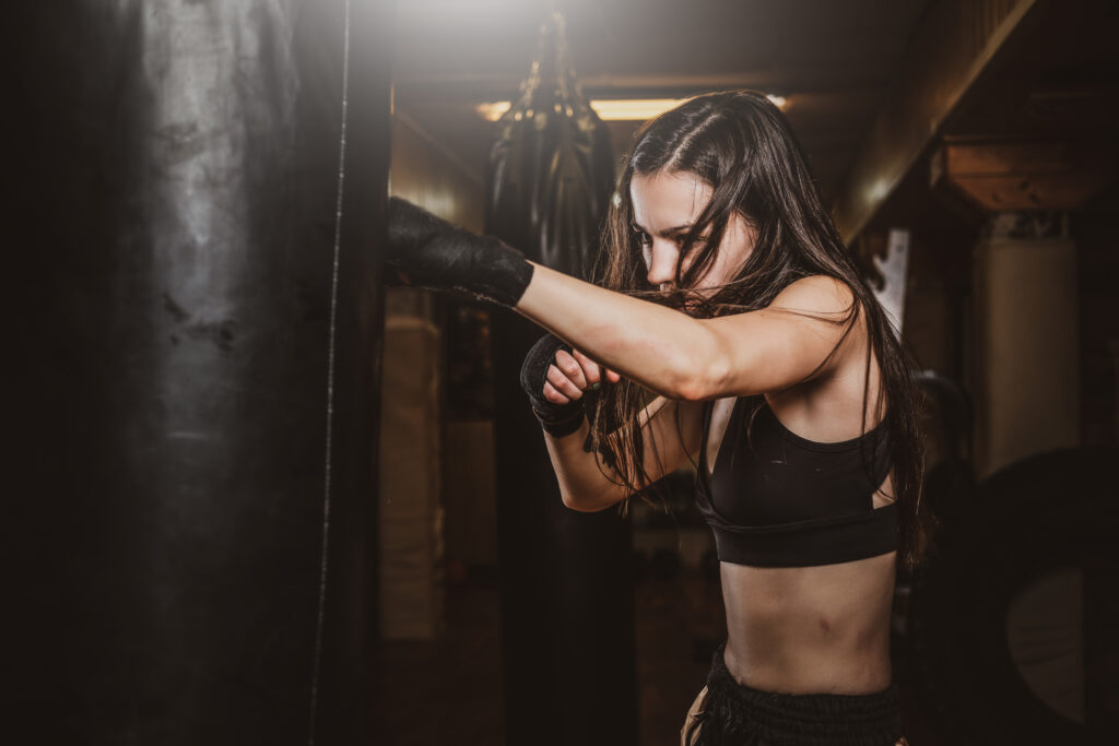 Exercice coordination boxe : une femme s'exerce sur un sac de frappe