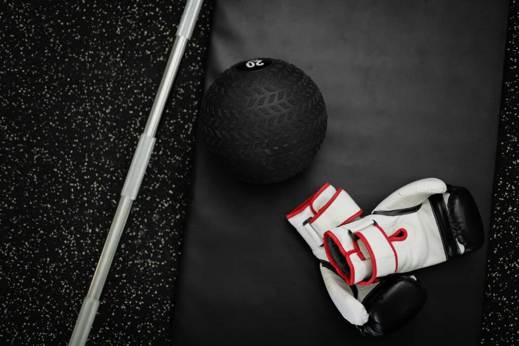 exercice medecine ball boxe : des gants de boxe et une medecine ball au sol