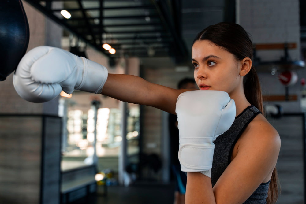 Exercice pliometrie boxe : Une femme s'entraîne à la boxe