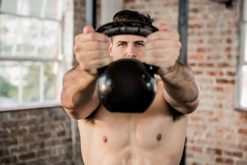 Exercice kettlebell boxe : un homme fait un exercice avec un kettlebell