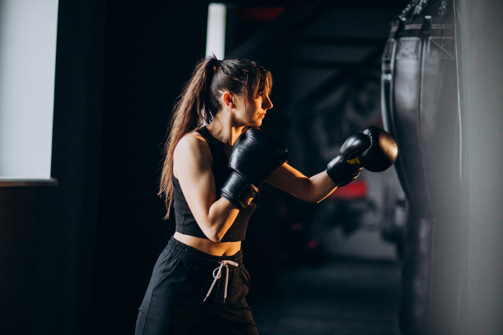 Exercice tabata boxe : une femme frappe sur un sac de frappe