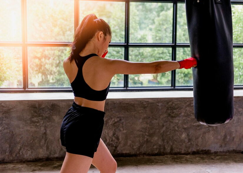 Exercice vma boxe : une femme s'entraîne sur un sac de frappe